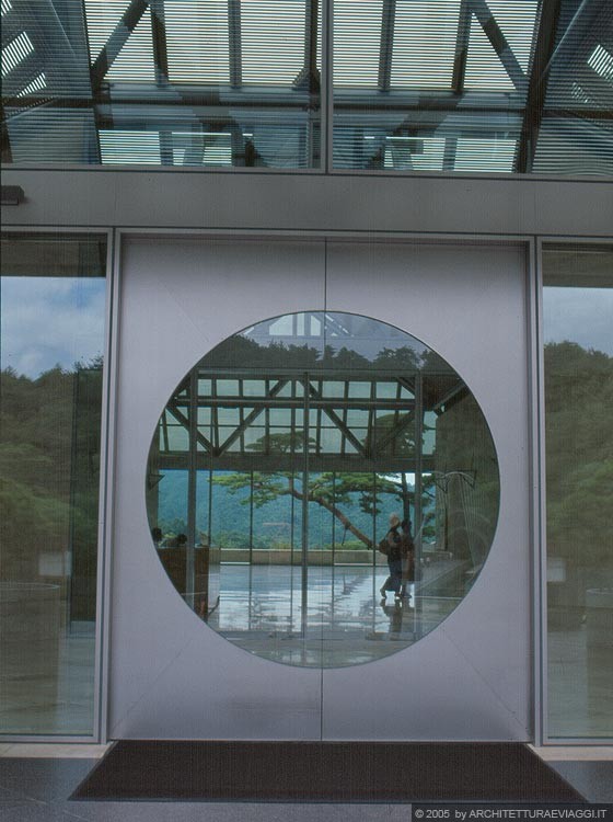 SHIGARAKI, SHIGA - MIHO MUSEUM - Il cerchio perfetto della porta di ingresso in vetro e metallo proietta la vista nell'atrio interno e da questo oltre la vetrata terminale fino al paesaggio