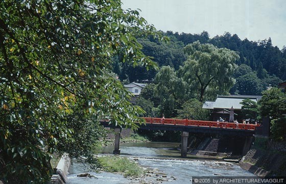 TAKAYAMA - Il rosso vermiglio del Nakabashi Bridge spicca tra la vegetazione e il fiume Miyagawa River