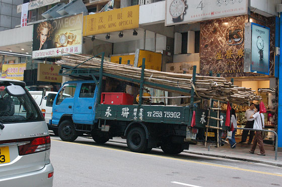 CENTRAL - Tra le pubblicità e le vetrine di Queen's Road Central, notiamo un camion che trasporta bambù per ponteggi