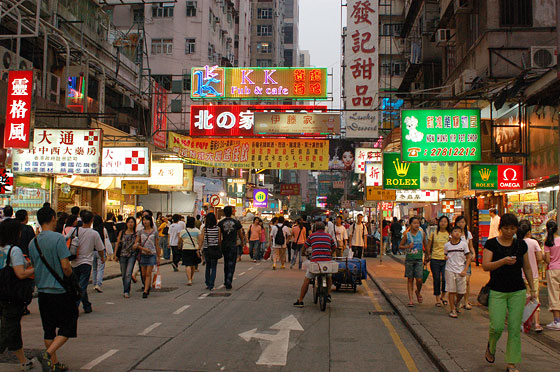 MONG KOK - E' l'imbrunire e le strade nei pressi del Mercato per le Signore si animano di luci artificiali e insegne pubblicitarie illuminate 