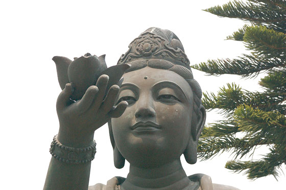 LANTAU - Il bel volto di una statua in bronzo di bodhisattva che offre doni al Grande Buddha del Monastero di Po Lin