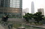 BANK OF CHINA TOWER. I giardini tra gli alti edifici con elementi lapidei geometrici: sullo sfondo emerge la grande mole dell'International Financial Centre