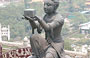 ISOLA DI LANTAU . Sullo sfondo della statua in bronzo di bodhisattva si intravedono gli edifici ed il tempio del Monastero di Po Lin tra il verde della collina