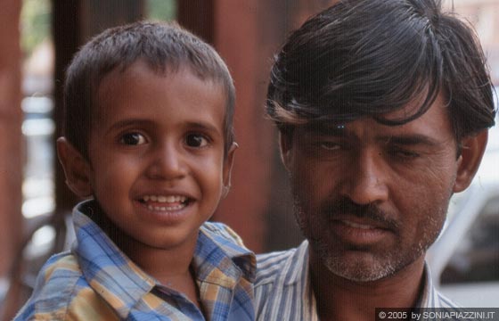 RAJASTAN ORIENTALE - Jaipur - lungo il bazar un padre ci chiede di fotografarlo con il bimbo in braccio