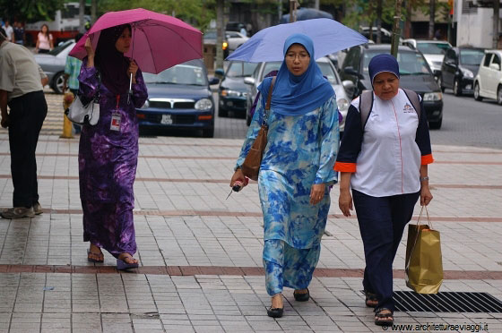 KUALA LUMPUR - Donne musulmane vestono abiti lunghi che coprono tutto il corpo eccetto la testa, i piedi e le mani