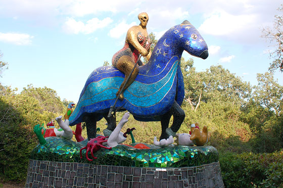 GIARDINO DEI TAROCCHI - La Morte, una ghignante figura dorata in sella ad un cavallo blu che falcia uomini e animali ai suoi piedi