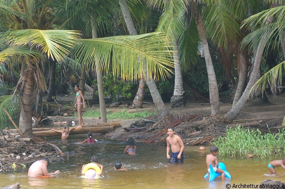 PLAYA CEPE - Dietro la spiaggia giovani venezuelani e giocano e fanno il bagno nelle acque stagnanti di questo fiume