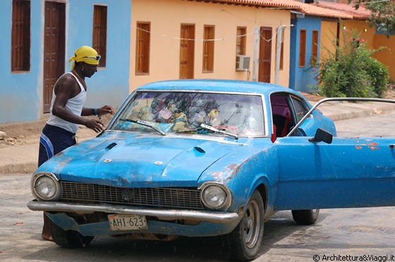 CHUAO - Un giovane venezuelano mostra muscoli, un'auto sgangherata di un azzurro raggiante e cianfrusaglie a suon di musica