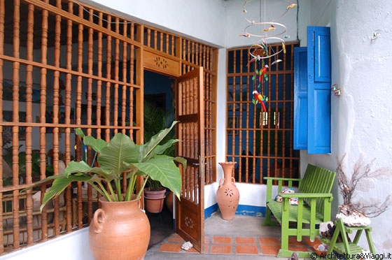 CHORONI' - L'abitazione è in diretta comunicazione con il piccolo patio attraverso queste ampie grate in legno - stretto rapporto tra interno ed esterno