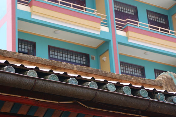 CAI RANG - Dal patio di una pagoda osserviamo questo edificio moderno che contrasta con la copertura in legno e ceramica della pagoda