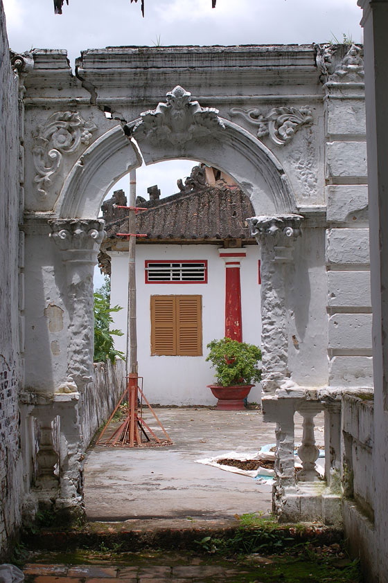 DELTA DEL MEKONG - Villaggio nei dintorni di Cai Rang: particolare della semplice facciata del tempio vista da un'arcata del patio