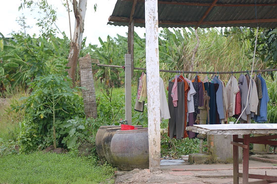DELTA DEL MEKONG - Villaggio nei dintorni di Cai Rang: panni stesi sotto una tettoia e sullo sfondo i banani del delta