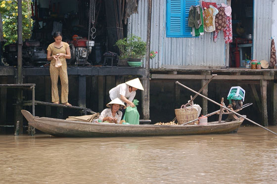DELTA DEL MEKONG - Dintorni di Cai Rang: donne si accingono a trasportare merce sulla loro imbarcazione
