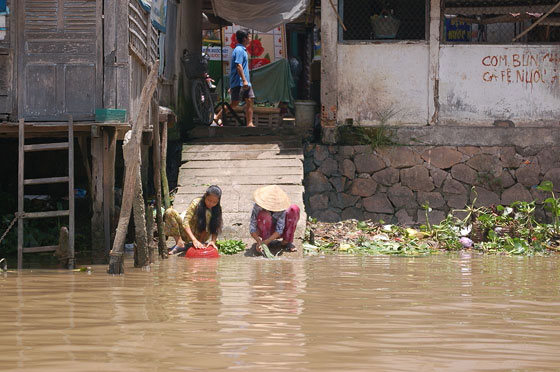 DELTA DEL MEKONG - Cai Rang: donne lavano piatti e panni nel fiume melmoso