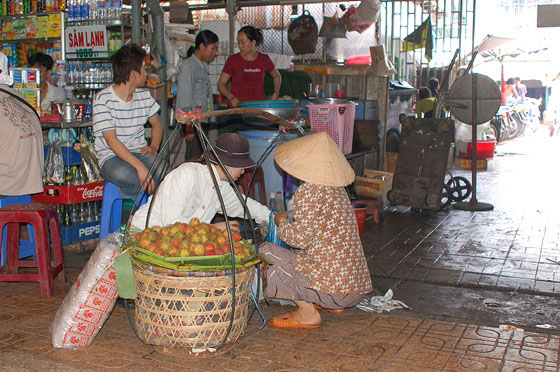 HO CHI MINH CITY - Mercato di Cholon: donna con cesti di rambutan