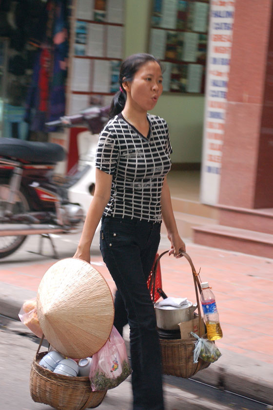 HANOI - Quartiere Vecchio: questa giovane vietnamita ha l'aria di portare stoviglie molto pesanti