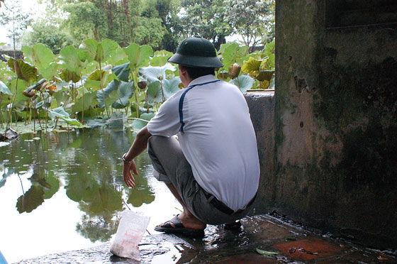 HOA LU - Tempio Le Dai Hanh (Duong Van Nga): un vietnamita aspetta con pazienza che i pesci dello stagno abbocchino al lamo
