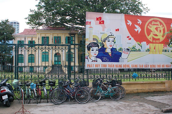 HANOI - Un grande manifesto di propaganda comunista e sullo sfondo un edificio coloniale