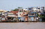 DELTA DEL MEKONG. Sulle rive del fiume si affacciano numerose palafitte di lamiera