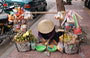 SAIGON. Donne con i loro cappelli conici e i cesti a bilanciere animano le strade della città