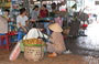 HO CHI MINH CITY. Mercato di Cholon: donna con cesti di rambutan