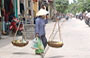 HOI AN. Vietnamiti trasportano frutta e verdura nei tipici cesti a bilanciere