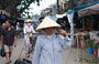 VIETNAM CENTRALE. Una donna trasporta merce al mercato centrale di Hoi An con i tipici cesti a bilanciere in spalla