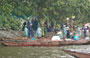 TAM COC. Il gruppo delle barcaiole al riparo dalla pioggia sotto il grande albero nei pressi del molo