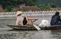 TAM COC. La barcaiola che rema con i piedi sullo sfondo di un caratteristico padiglione o tempio vietnamita